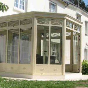 véranda en kit sur mesure beige avec toiture à chéneaux périmétriques et baies vitrées