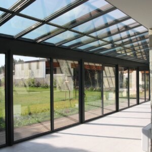 véranda sur mesure en alu gris anthracite avec toiture en verre