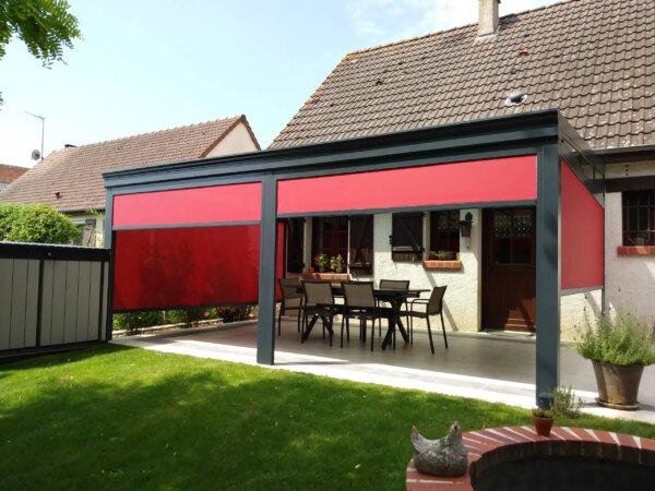 Pergola Gris Anthracite avec stores rouges sur terrasse en béton