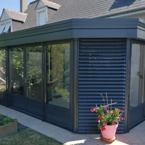 véranda à pans coupés en alu gris sur mesure sur terrasse